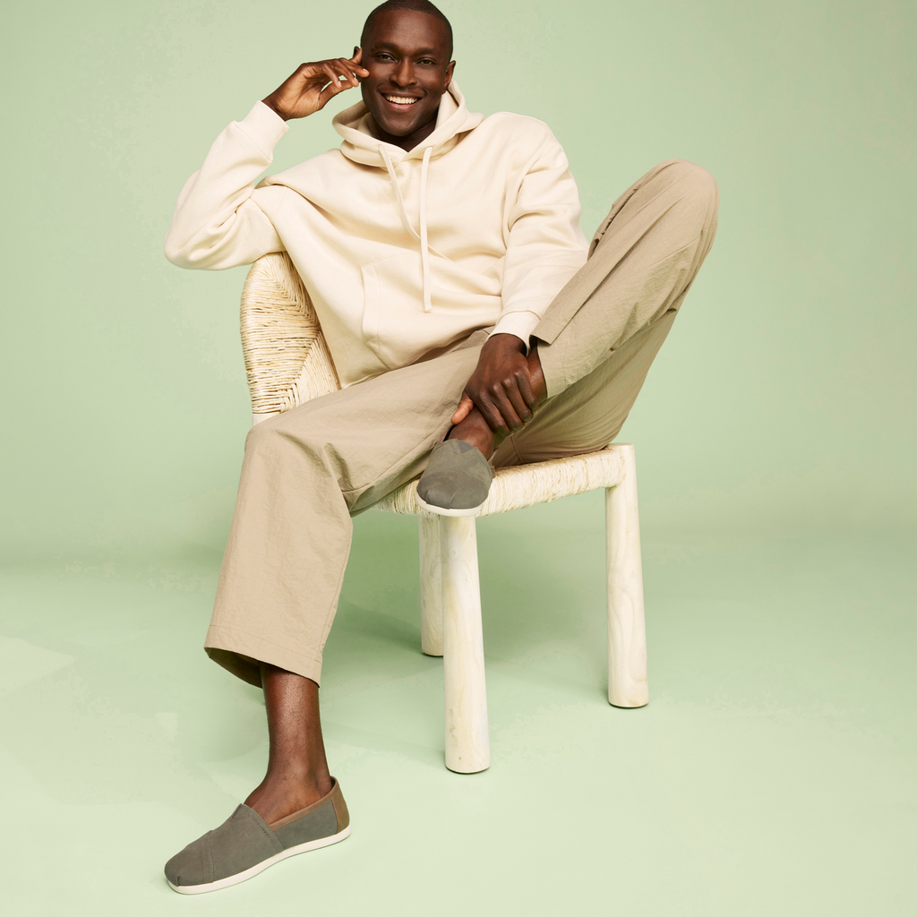 Alpargata In  Green With Synthetic Trim On Model Sitting On Chair Smiling