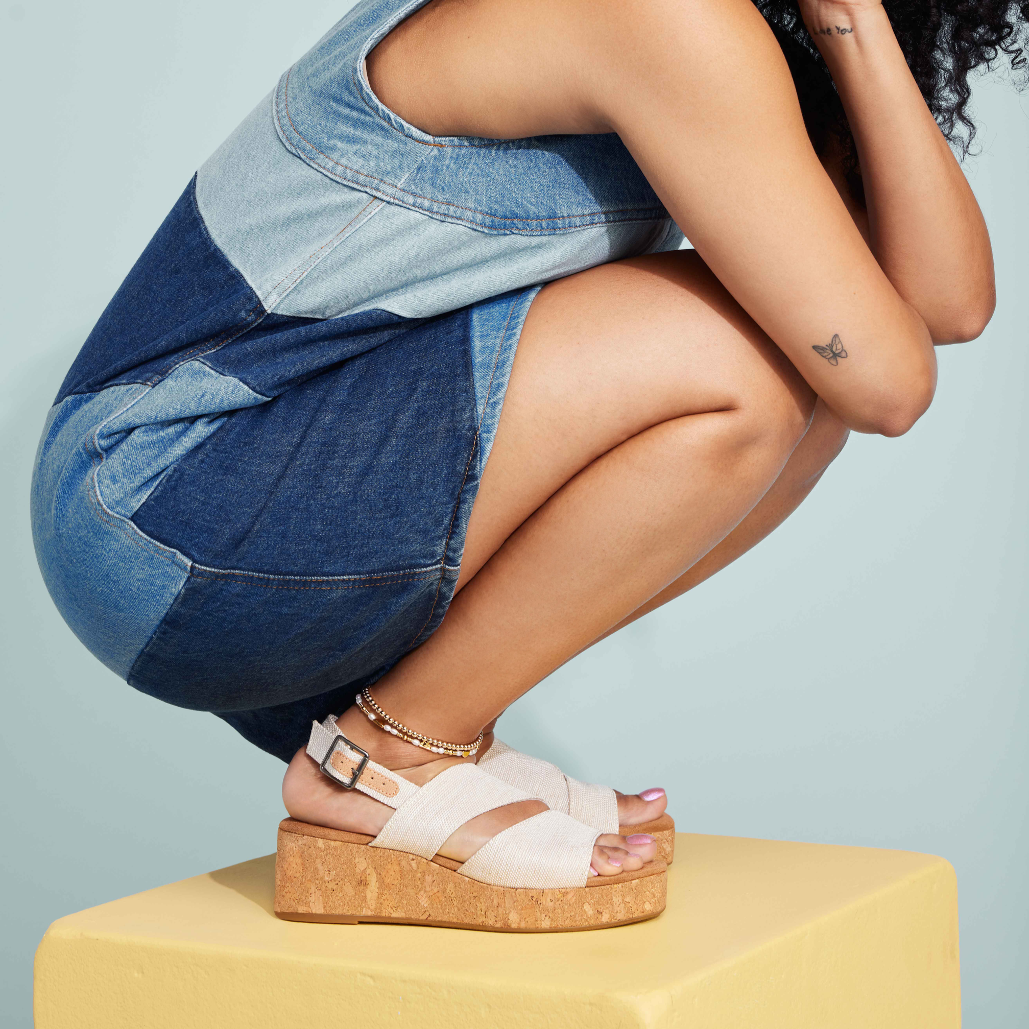 Claudine Flatform Cork Wrap Wedge Sandal On Model Squatting In Denim Jumper